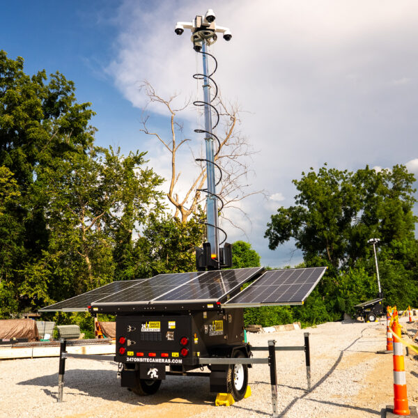Mobile surveillance unit with solar panels at construction site.