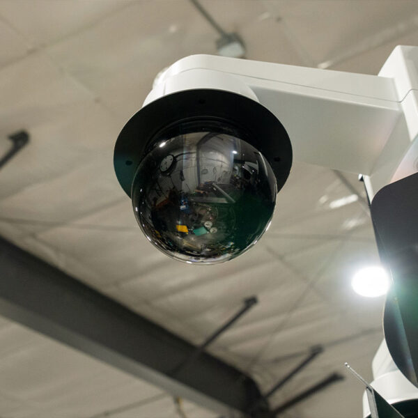 Dome security camera on industrial building ceiling.