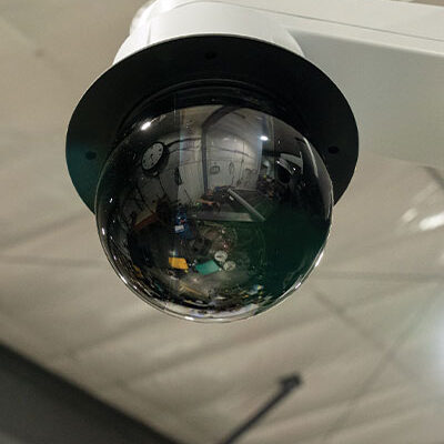 Ceiling-mounted dome security camera in industrial interior.