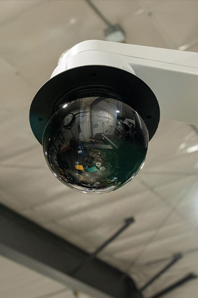 Ceiling-mounted dome security camera in industrial interior.
