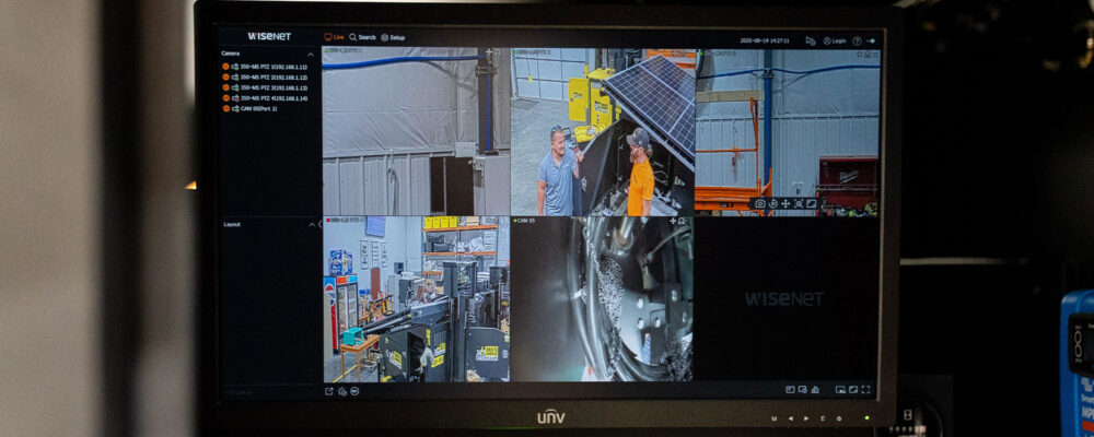 Security monitor shows four feeds of people and equipment.