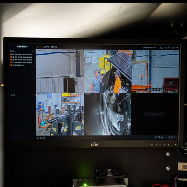 Security monitor shows four feeds of people and equipment.