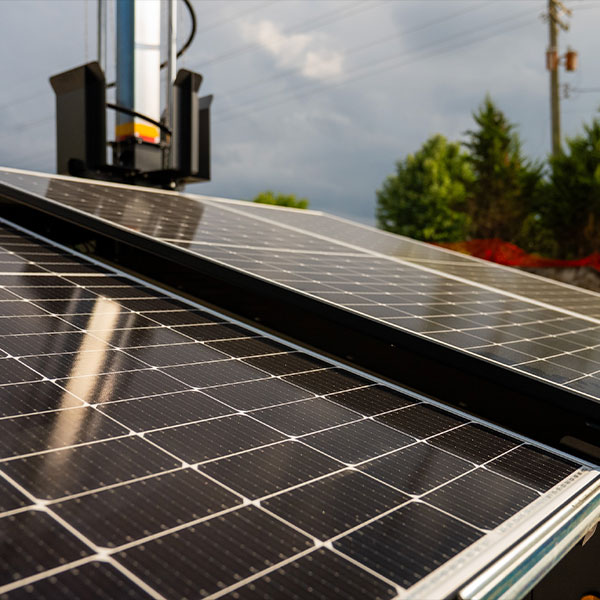 Solar panels outdoors, reflecting light, with cloudy sky.
