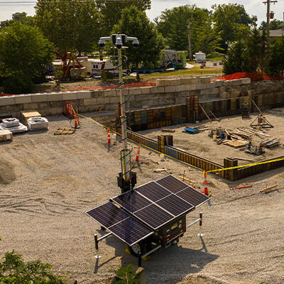 Solar surveillance unit at construction site with equipment.