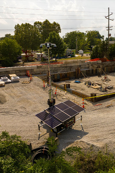 Solar surveillance unit at construction site with equipment.