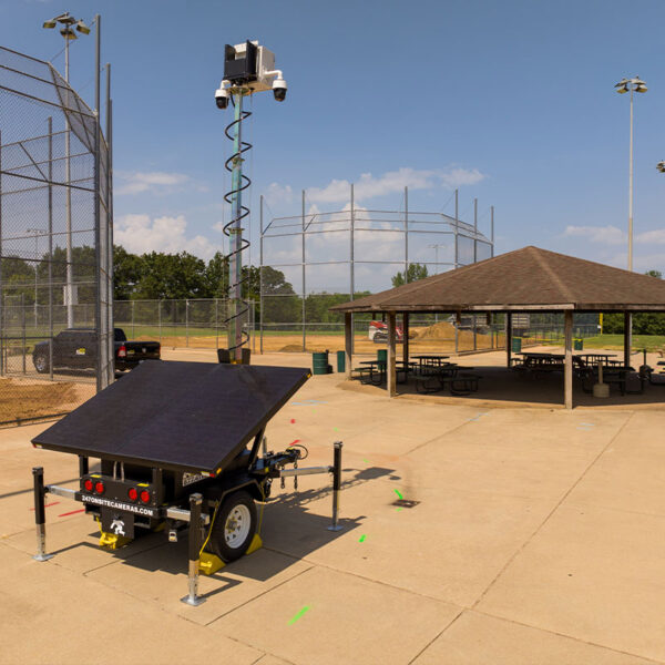 Solar-powered security camera trailer by baseball field.