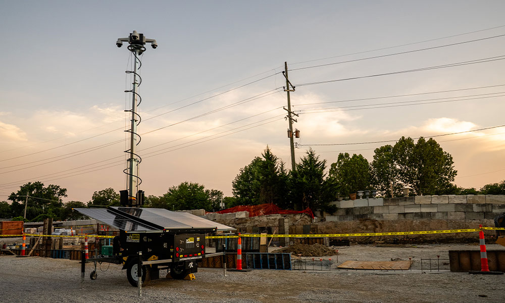 Mobile solar camera at construction site during sunset.